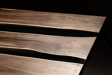 Expensive vintage furniture. The table is covered with epoxy resin and varnished. Luxury quality wood processing. Wooden table on a dark background. Black river made of epoxy resin.