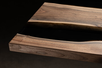 Expensive vintage furniture. The table is covered with epoxy resin and varnished. Luxury quality wood processing. Wooden table on a dark background. Black river made of epoxy resin.