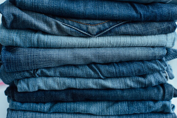 Stack of a stack of old jeans various shades of blue jeans. Denim jeans texture. Denim background texture for design. Canvas denim texture.
