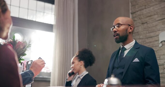 Hotel, employees or guest at reception for check in, hospitality or accommodation with welcome. Vacation, people or workers with luxury, honeymoon or friendly service with concierge, smile or tourism