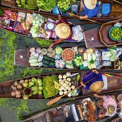 Fototapeta premium A floating market on a canal in Thailand. Boats laden with fresh produce, vegetables and fruit. Market traders.
