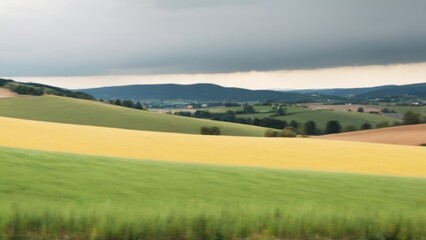 Fototapeta premium clouds over an otherwise plowed country near a valley and town,