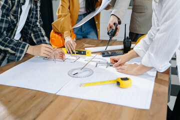 Creative architect projecting on the big drawings with architectural project at construction site