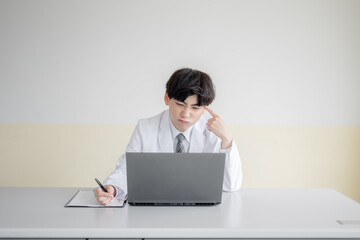 頭を抱える白衣の男性