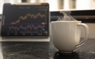Business Morning at the Workspace: A Coffee Cup on a Desk with a Laptop Open to Stock Charts and Graphs, Reflecting the Intersection of Technology, Finance, and a Busy Work Day