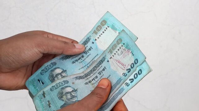 A woman is counting Bangladesh money. Close-up of counting Bangladeshi 100 taka banknotes.