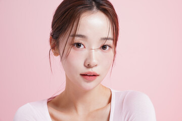 ピンク背景で撮影をした若い女性のキャッチーなビューティー...