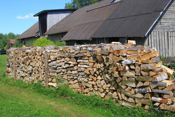 Cut firewood stacked outside. Background of wooden logs