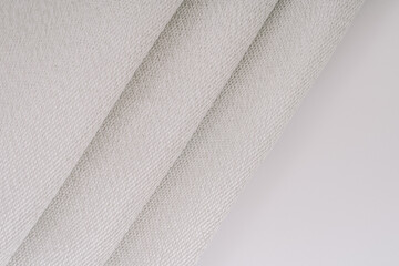 Close-up of fiberglass woven fabric with visible metal threads, featuring folded sections that showcase the detailed, textured pattern.