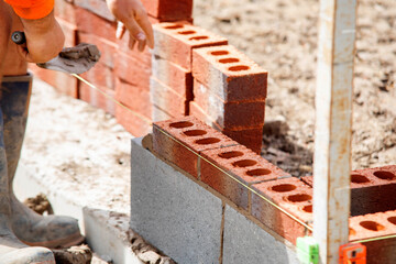 Building Brick Wall With Precision at  Construction Site During the Day