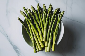 fresh green asparagus in bowl on marble background