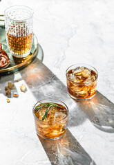 a glass of whiskey with rosemary