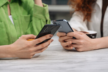 Two Friends Exchanging Messages While Sitting at Table in Cozy Cafe During the Afternoon