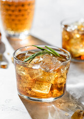 a glass of whiskey with rosemary