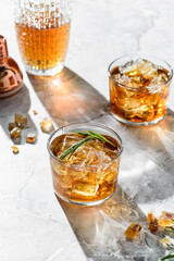 a glass of whiskey with rosemary