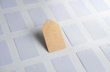 Mockup of a brown kraft paper price tag standing out among white labels. with clipping path