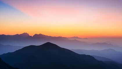 Serene mountain landscape at sunset with layered silhouettes of hills and distant peaks against a colorful sky