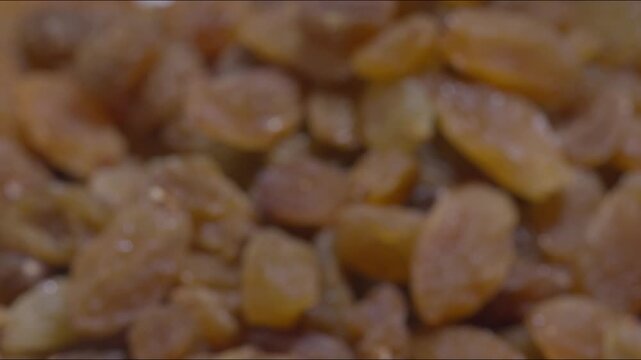 A zooom out and steady shot of Golden Raisins on a table