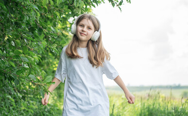 A child  with headphones listening to music and dancing