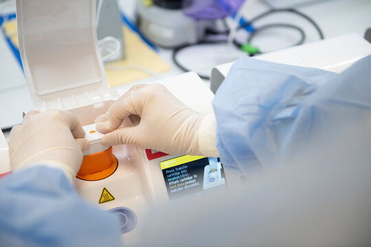Lab technician placing cartridge into point-of-care testing mach