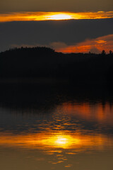 Obraz premium Sunset over a magnificent fishing lake in the Canadian forest