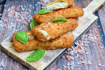 Close up of   Crispy breaded  deep fried fish fingers with breadcrumbs served  with remoulade sauce and  lemon Cod Fish Nuggets on rustic wood table background