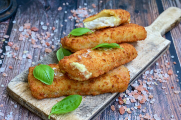 Close up of   Crispy breaded  deep fried fish fingers with breadcrumbs served  with remoulade sauce and  lemon Cod Fish Nuggets on rustic wood table background