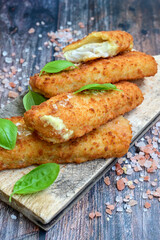 Close up of   Crispy breaded  deep fried fish fingers with breadcrumbs served  with remoulade sauce and  lemon Cod Fish Nuggets on rustic wood table background