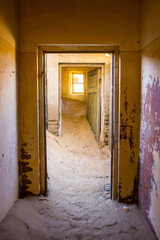 Golden morning sunlight shining through a window into one of the sand filled houses of the eery,...