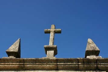 Typical stone cross on a roof top of a church in Northern Portugal