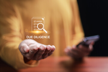Due diligence concept. Businessman using smartphone with due diligence icon on virtual screen for due diligence, assessment of the company's assets and liabilities