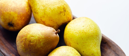 A basket of pears with a few of them still attached to their stems