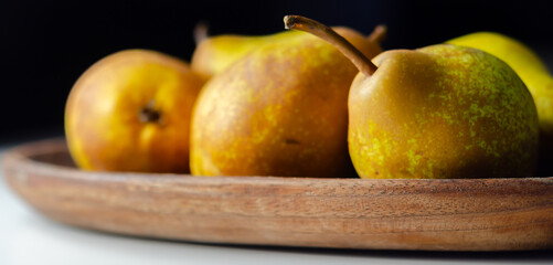 A basket of pears with a few of them still attached to their stems