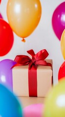 Elegantly Wrapped Gift Box in Kraft Paper Tied with a Red Ribbon Amidst a Sea of Vibrant Balloons, Exuding Festive Celebration and Joy