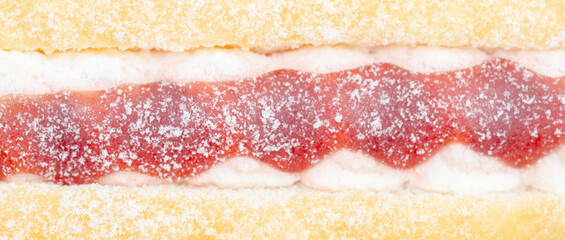 A jelly donut with a jelly filling and a powdered sugar topping