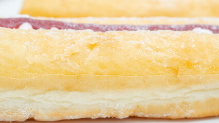 A jelly donut with a jelly filling and a powdered sugar topping