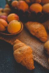 Fresh apricots and croissants on a burlap cloth
