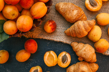 Fresh apricots and croissants on a burlap cloth