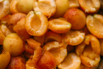 Close-up of halved apricots showcasing their vibrant orange color and juicy texture. The fresh...