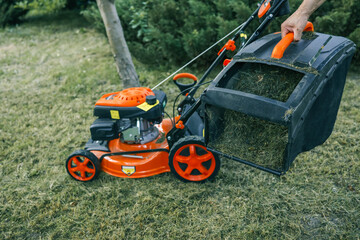 The gardener is tending the garden, the lawn mower is cutting the grass