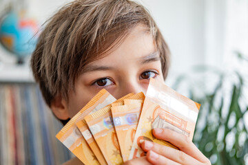 child holding euros, euro banknotes money in fan, euro money, rejoices in success, anticipates what...