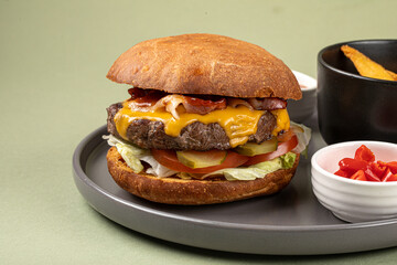 Portion of burger with potato wedges on green background