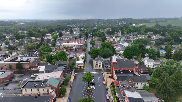 Summer thunderstorm over quaint small town in USA. Aerial reverse dolly revealing historic buildings in town square. Rainy day in July.