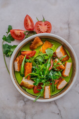 chicken with vegetables in green sauce on a light background