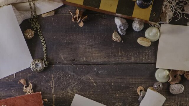 Slow and cinematically animations. It features a composition of old objects . on the wooden table, there is an old camera, a book, a roll of paper tied with a string, a seashell, chess, pebbles