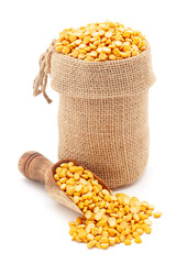 Close-up of Organic Bengal Gram (Cicer arietinum) or split yellow chana dal, in a jute bag and on a scoop, Isolated on a white background.