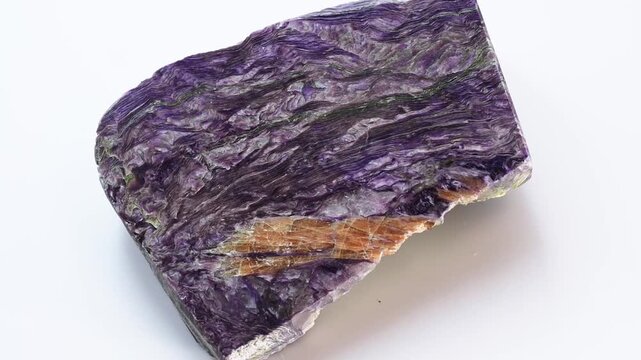 A sample of the charoite stone on a white background. Charoite is a purple colored mineral. Charoit breccia spinning on a white background.