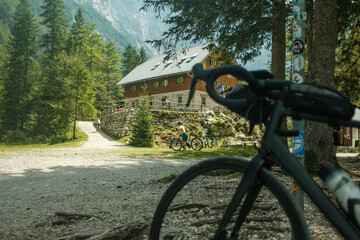 Gravel bicycle in the mountains, with cottage and mountains in the background