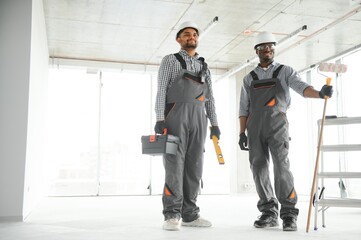 multicultural builders in hardhats at construction site