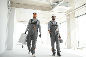 multicultural builders in hardhats at construction site
